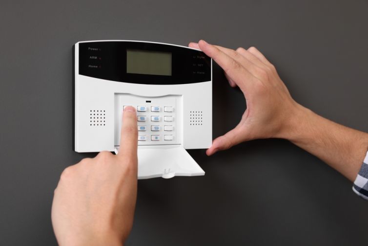Man,Entering,Code,On,Home,Security,Alarm,System,Near,Gray